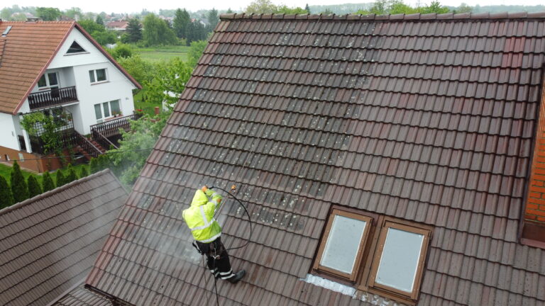 pracownik myjący zabrudzoną dachówkę betonową